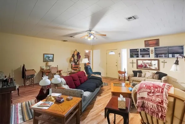 a living room with furniture a chandelier and a dining table