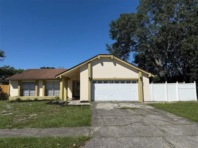 a view of a house with a yard and large tree