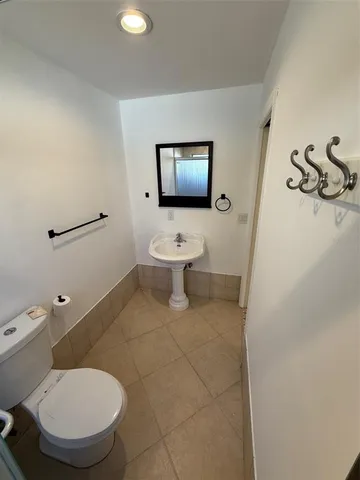 a bathroom with a toilet a sink and mirror