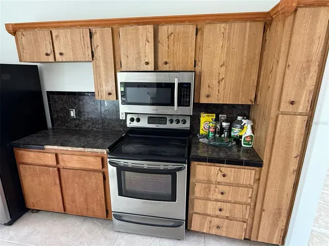 a kitchen with granite countertop cabinets stainless steel appliances and wooden floor