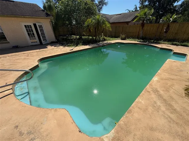 a swimming pool with outdoor seating and yard