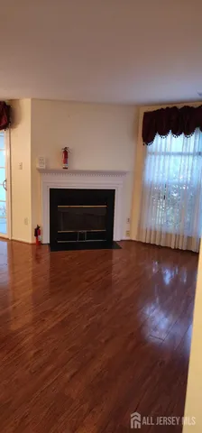 a living room with hard wood floors and a fireplace