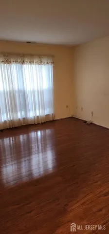 a view of room with hardwood floor and window