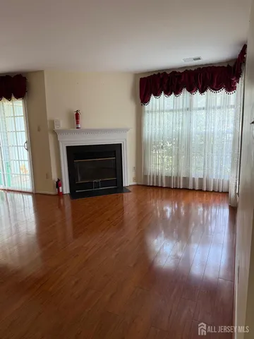 a view of a room with wooden floor fireplace and a window