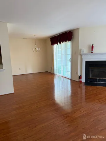a view of empty room with wooden floor and fireplace