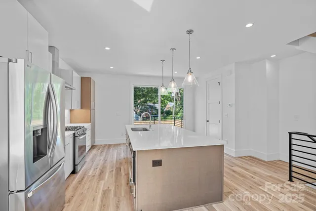 a kitchen with stainless steel appliances granite countertop a sink stove and refrigerator