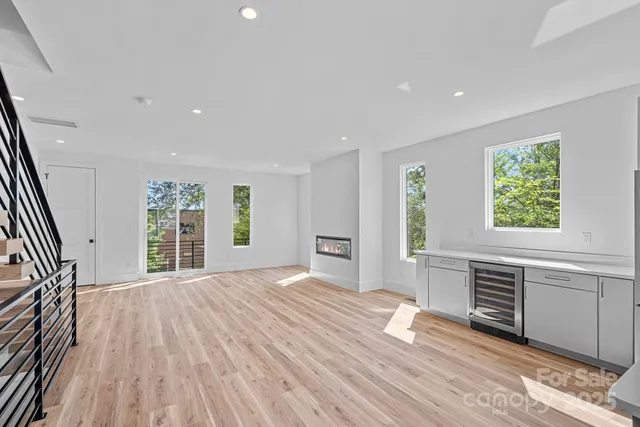 a view of a big room with wooden floor fireplace and windows