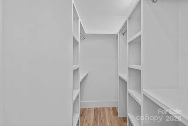 a view of walk in closet with empty racks