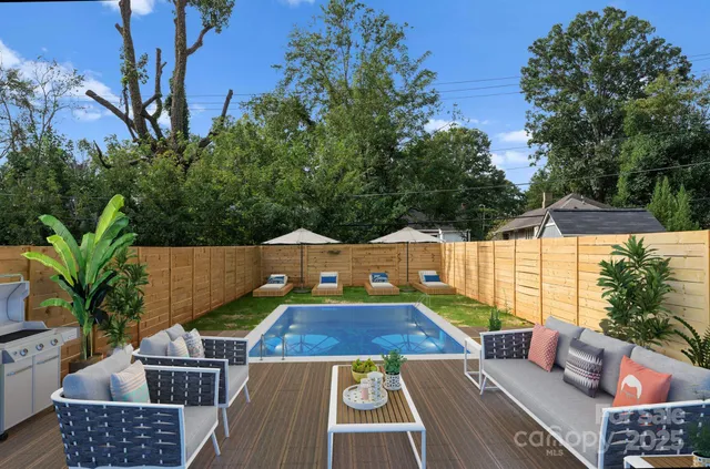 an aerial view of a house with swimming pool and seating