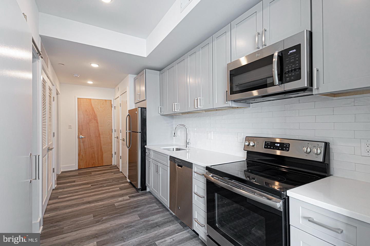 1245 Ridge Avenue, Unit 103 Philadelphia, PA 19123 - Photo 13 of 18 a kitchen with stainless steel appliances a stove microwave and sink