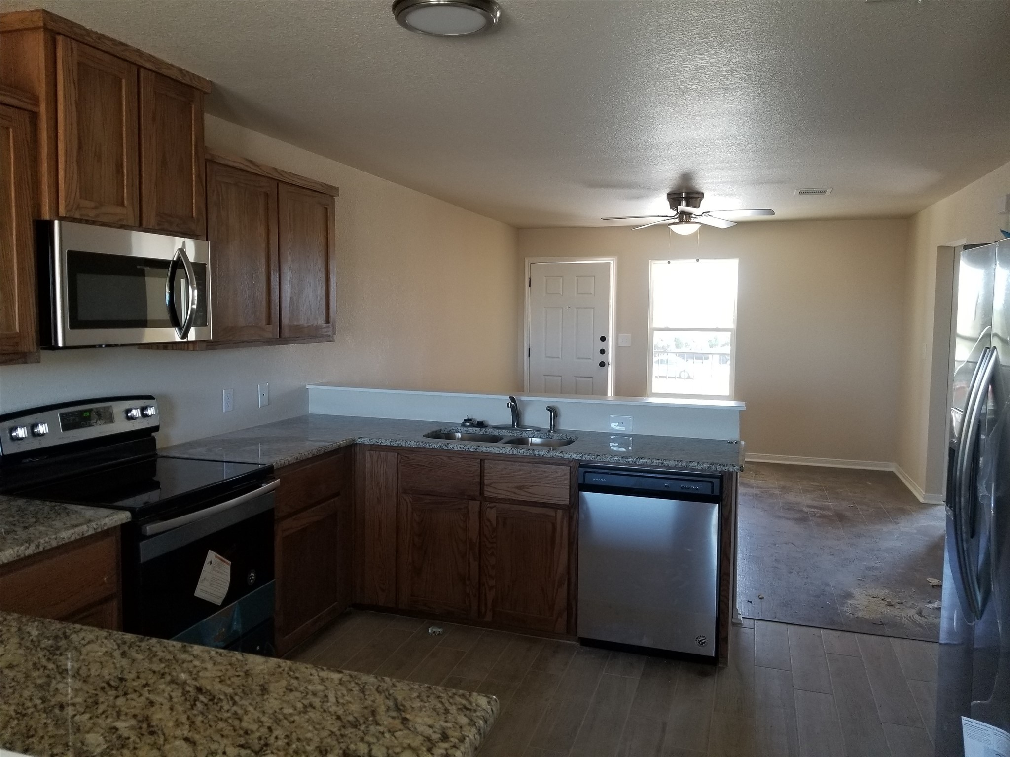 92 Sandstone Drive, Unit B Jarrell, TX 76537 - Photo 2 of 4 a kitchen with stainless steel appliances granite countertop a stove a sink and a microwave