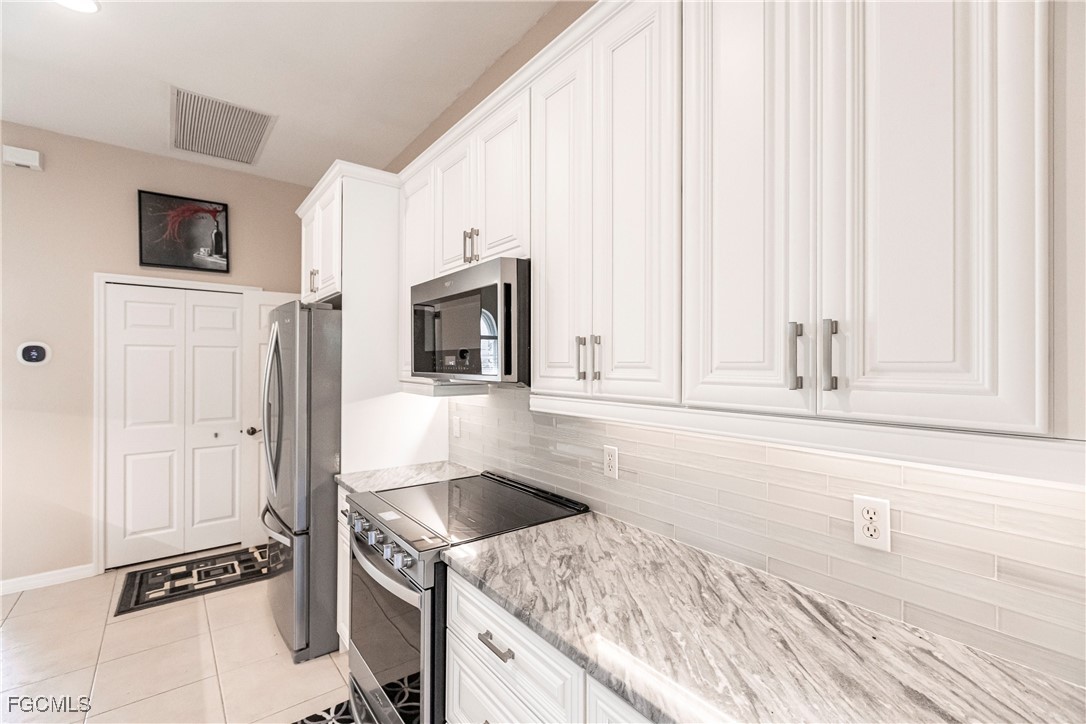 9013 West Ridge Court Fort Myers, FL 33912 - Photo 22 of 43 a kitchen with granite countertop a sink a stove and cabinets