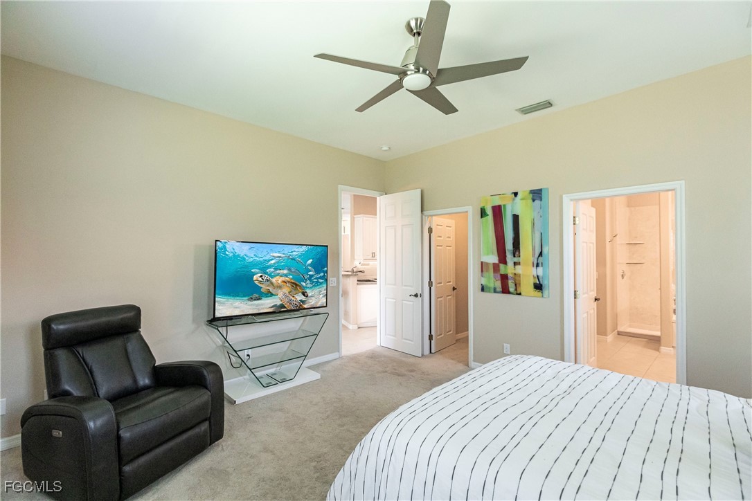 9013 West Ridge Court Fort Myers, FL 33912 - Photo 26 of 43 a bedroom with a bed window and a flat screen tv