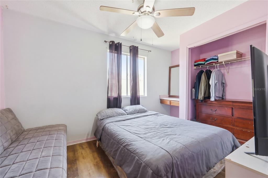3027 Queens Gate Road Orlando, FL 32818 - Photo 23 of 34 a bedroom with a bed and a chandelier