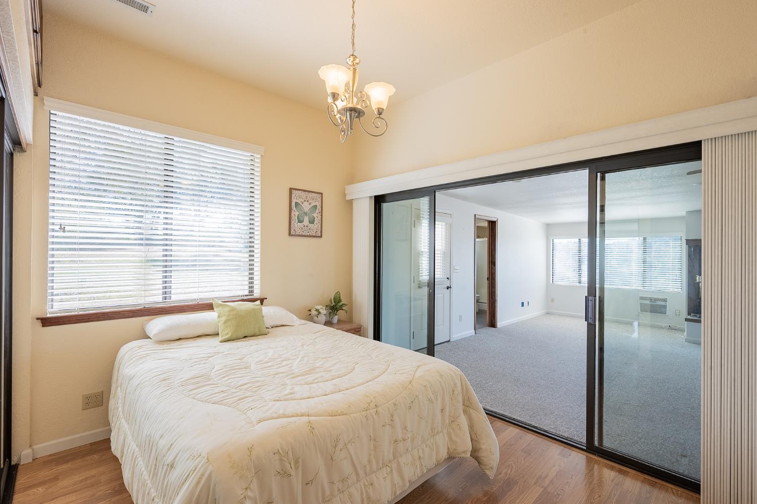 5912 Old Gulch Road San Andreas, CA 95249 - Photo 14 of 71 a bedroom with a large bed and a chandelier