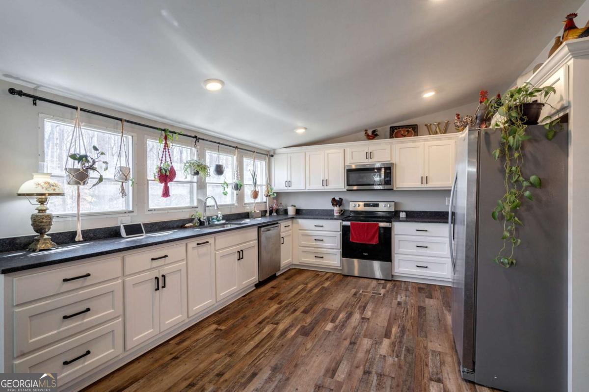 218 Sol Drive Commerce, GA 30529 - Photo 12 of 48 a kitchen with granite countertop a refrigerator and white cabinets