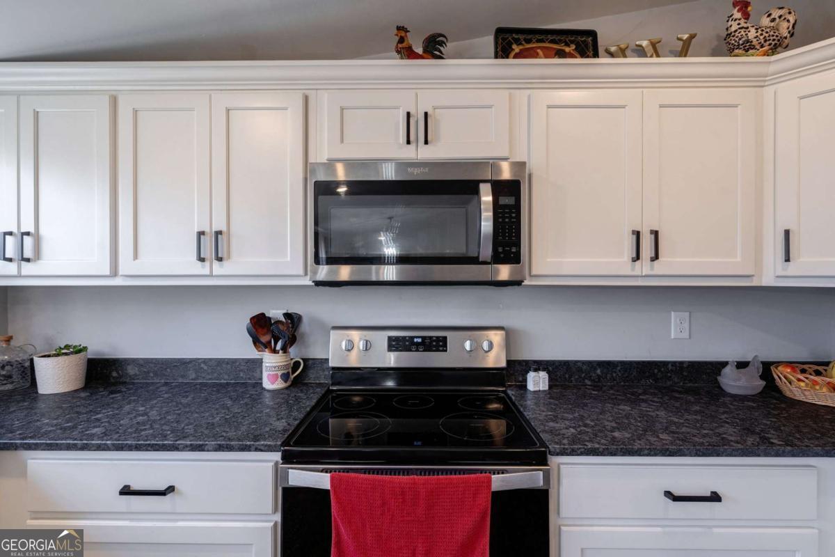 218 Sol Drive Commerce, GA 30529 - Photo 16 of 48 a kitchen with white cabinets and appliances