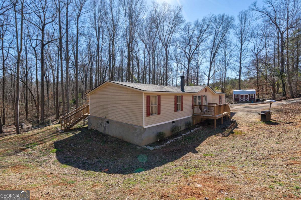 218 Sol Drive Commerce, GA 30529 - Photo 3 of 48 a white house covered with tall trees