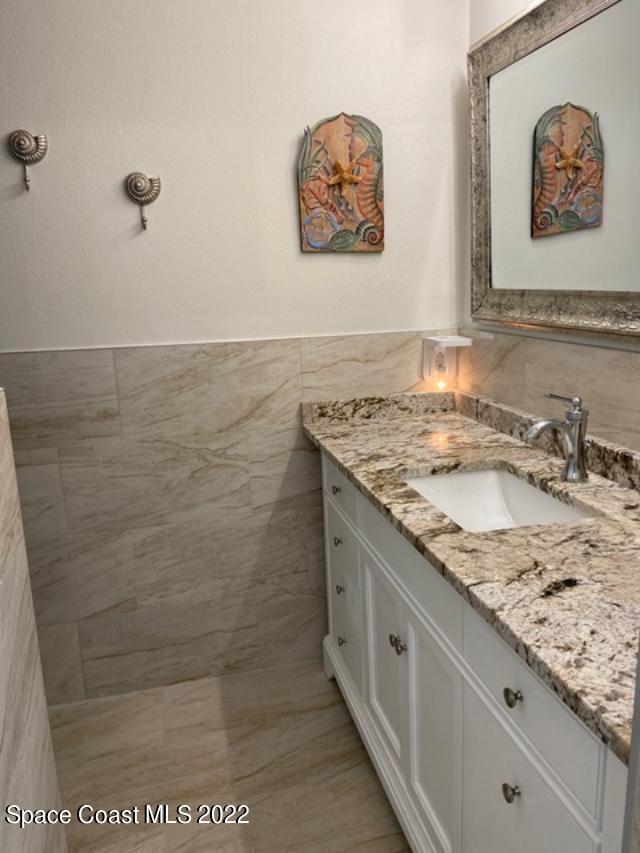 146 Bimini Road Cocoa Beach, FL 32931 - Photo 16 of 41 a bathroom with a granite countertop sink a mirror and shower