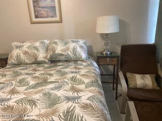 146 Bimini Road Cocoa Beach, FL 32931 - Photo 20 of 41 a bedroom with a bed and a lamp