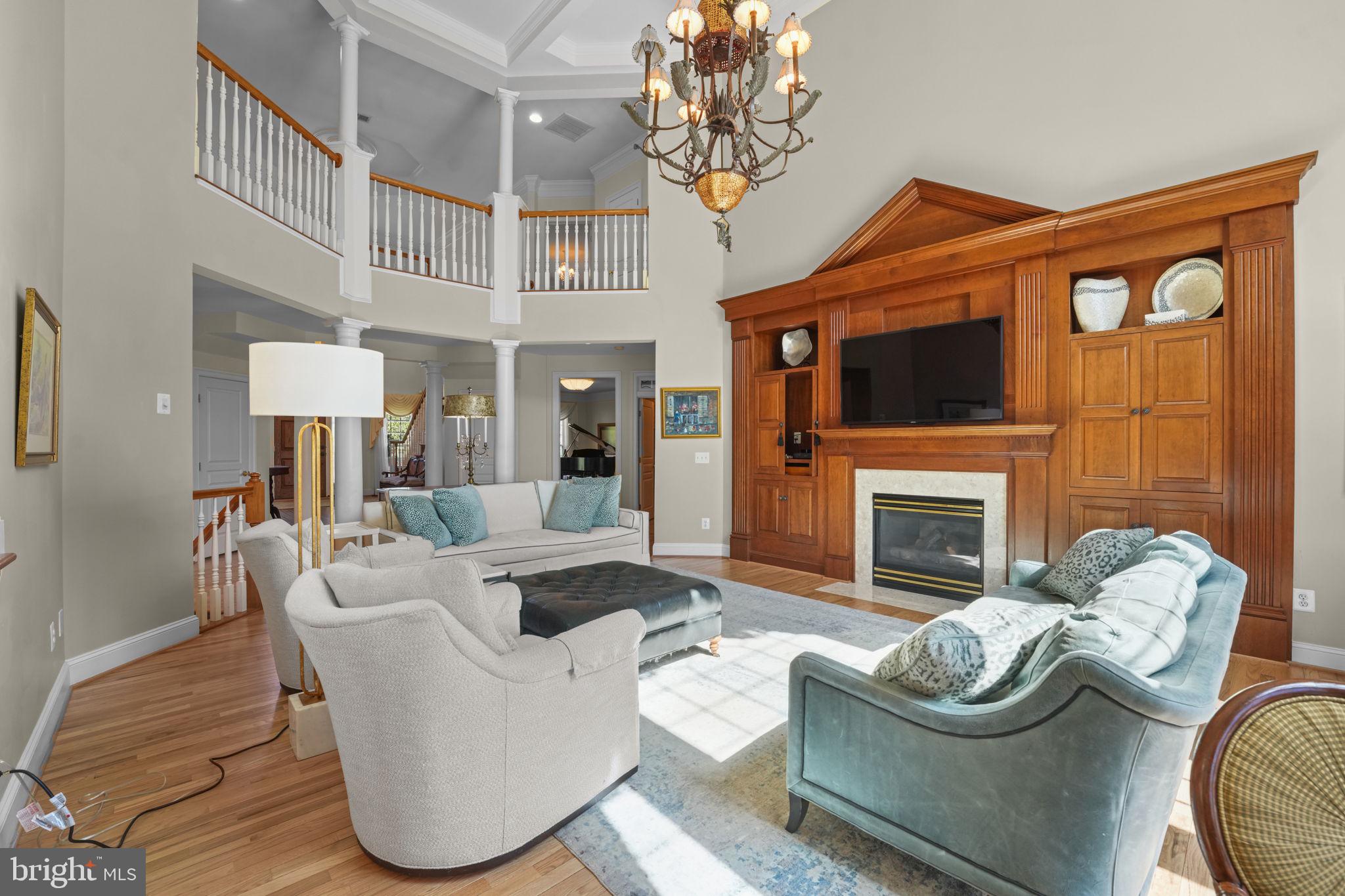 11431 Woolington Road Great Falls, VA 22066 - Photo 11 of 49 a living room with furniture a fireplace and a chandelier