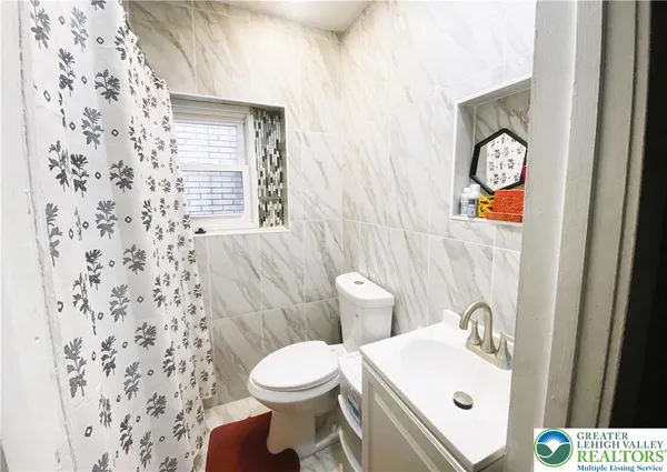 a bathroom with a sink toilet and window