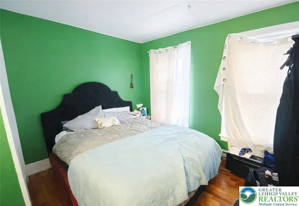 a bed sitting in a bedroom next to a window