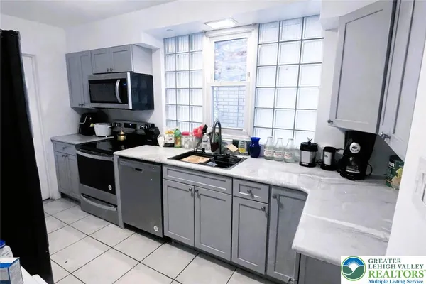 a kitchen with stainless steel appliances a stove a sink a microwave and cabinets