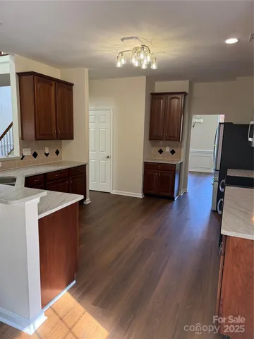 a kitchen with cabinets and wooden floor