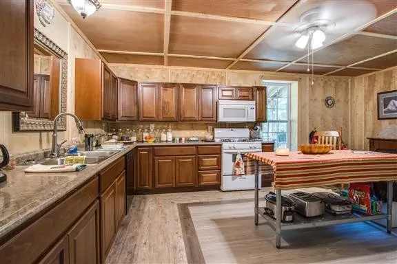 a kitchen with a sink appliances cabinets and furniture