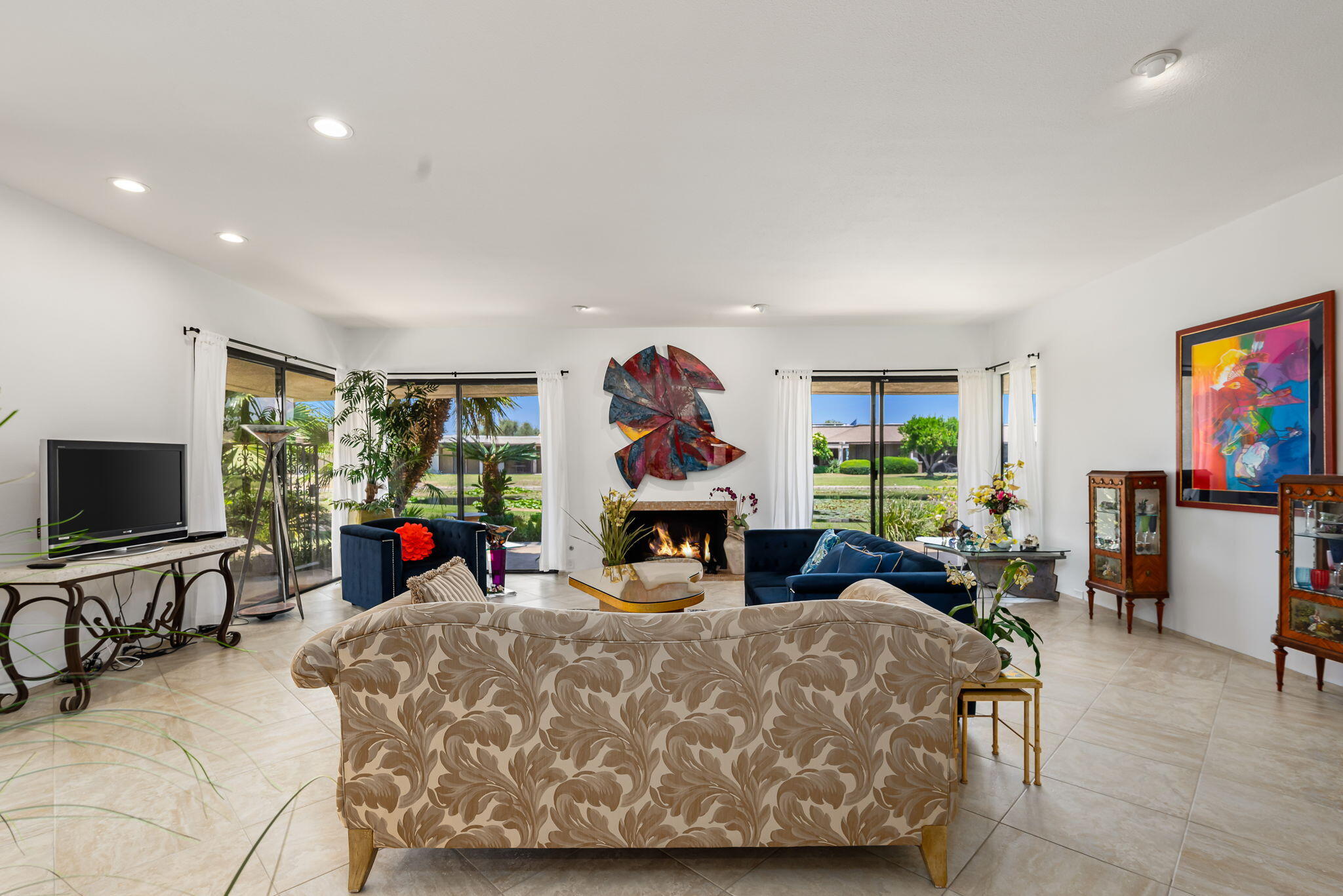 4 Reed Court Rancho Mirage, CA 92270 - Photo 4 of 42 a bed room with furniture a flat tv screen and a fireplace