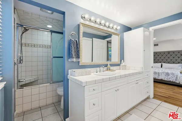 a bathroom with a double vanity sink mirror and shower