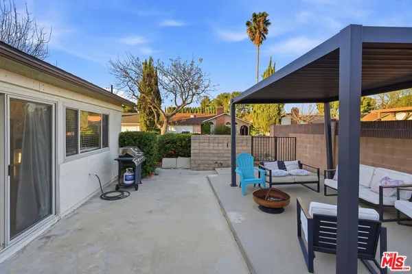 a view of a white house with a yard and potted plants