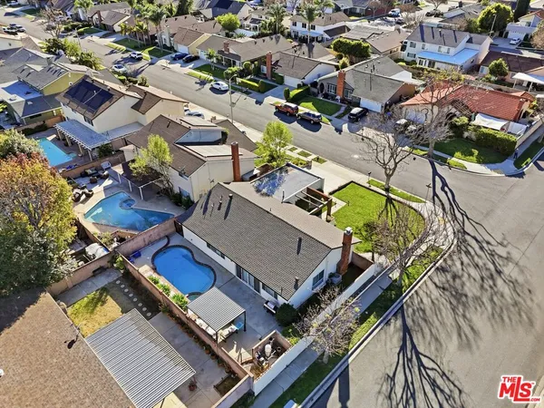 an aerial view of a swimming pool with outdoor seating and mountain view