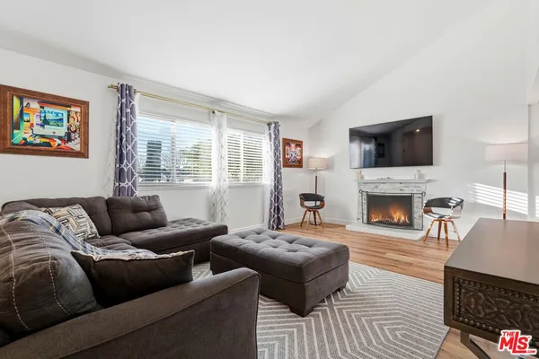 a living room with furniture a fireplace and a flat screen tv