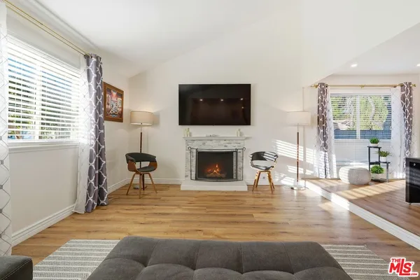 a living room with furniture a fireplace and a flat screen tv