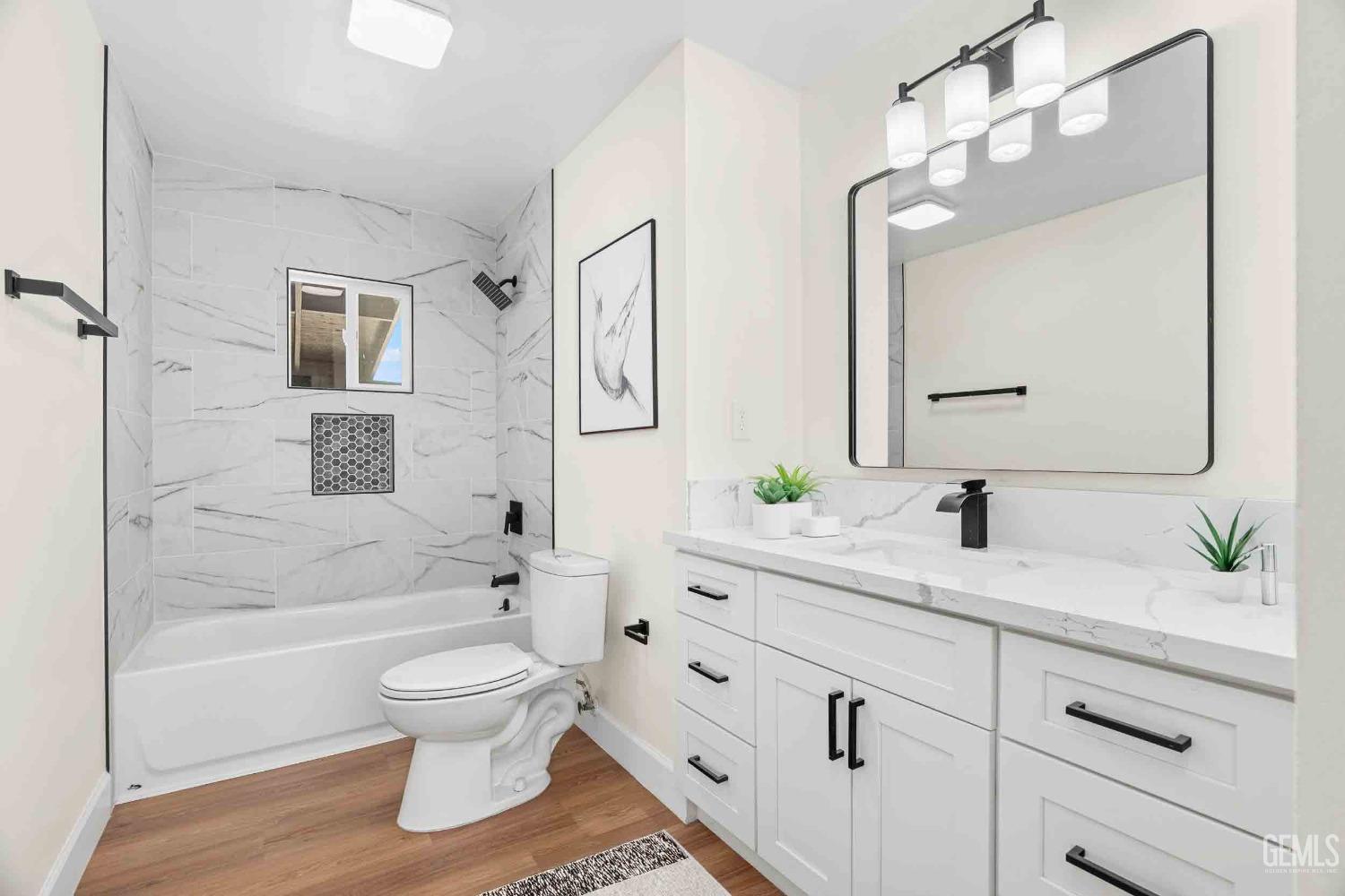 Undisclosed Address Bakersfield, CA 93307 - Photo 21 of 46 a bathroom with a toilet a sink a mirror a bathtub and vanity