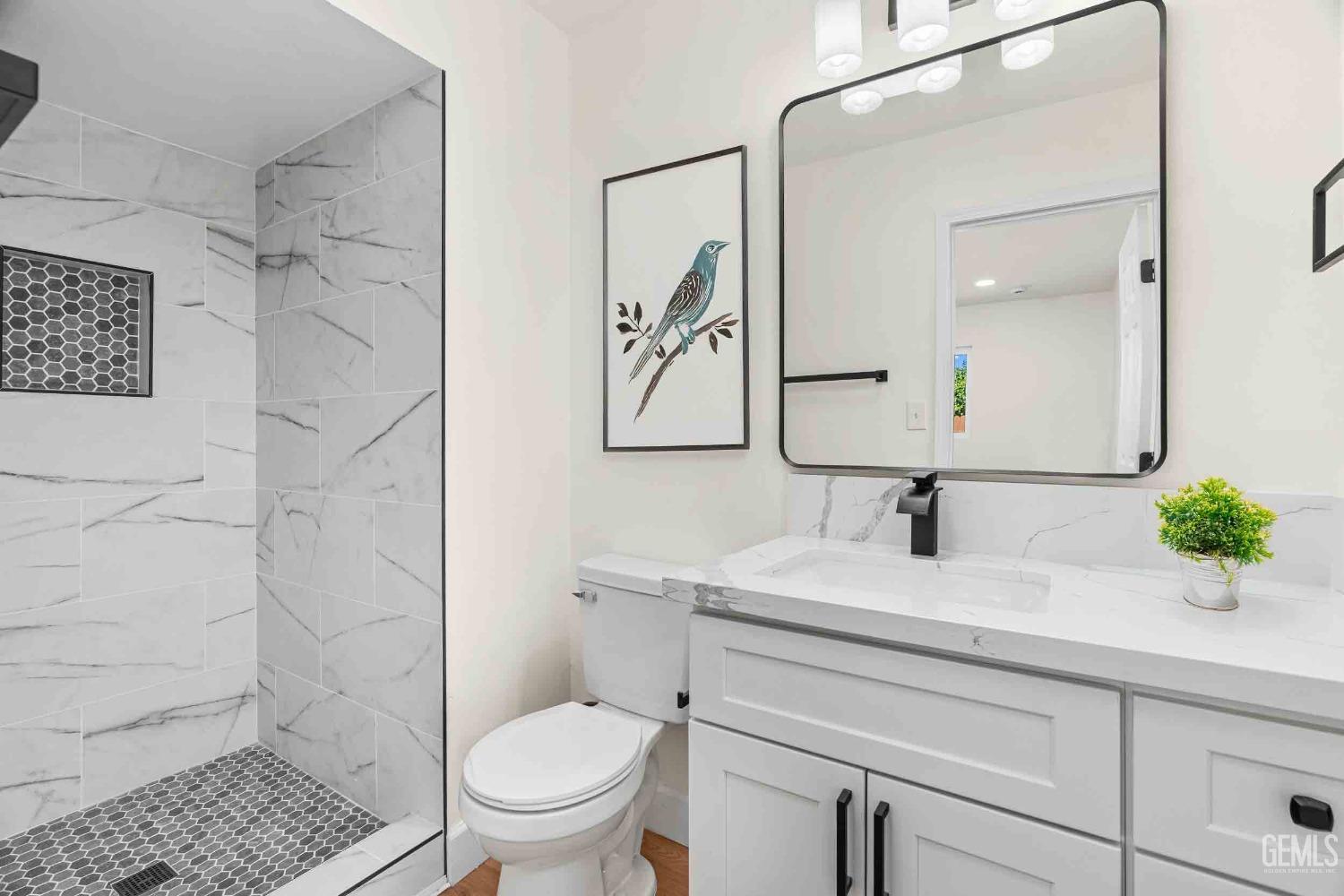 Undisclosed Address Bakersfield, CA 93307 - Photo 32 of 46 a bathroom with a sink a toilet and a mirror