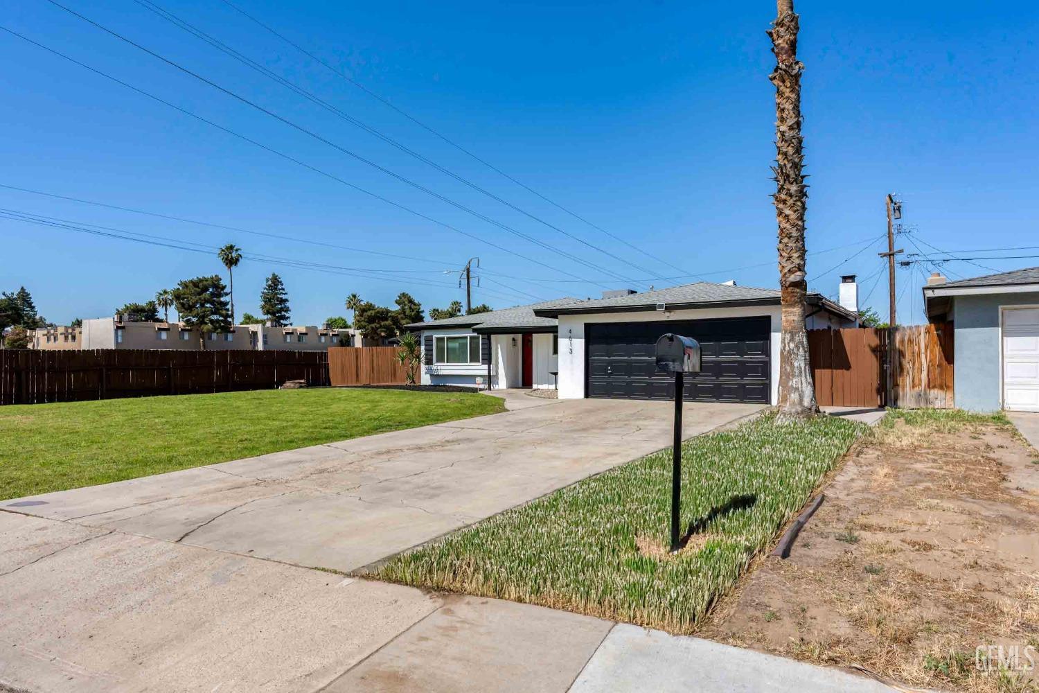 Undisclosed Address Bakersfield, CA 93307 - Photo 4 of 46 a front view of a house with a yard and garage