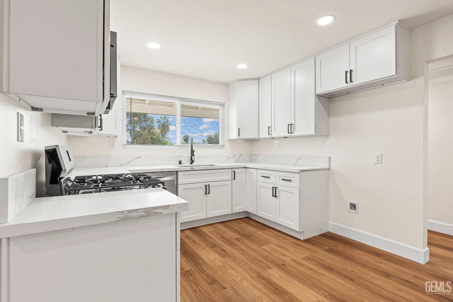 Undisclosed Address Bakersfield, CA 93307 - Photo 10 of 46 a kitchen with a stove a sink and a refrigerator