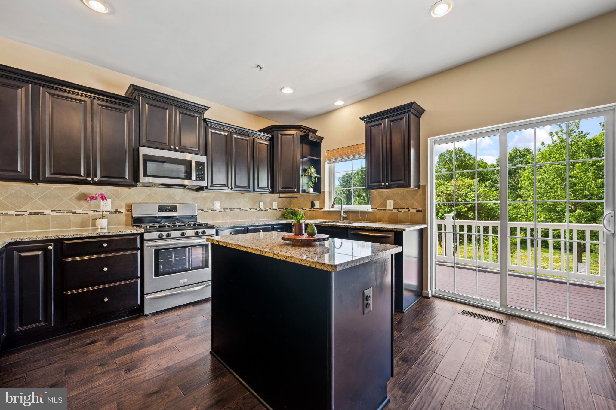 7062 Foxton Way Hanover, MD 21076 - Photo 11 of 41 a kitchen with kitchen island granite countertop wooden floors stainless steel appliances and sink