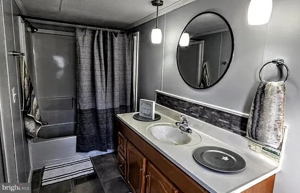 a bathroom with a sink a mirror a toilet and a window