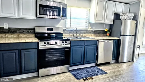 a kitchen with stainless steel appliances granite countertop a stove a refrigerator and a microwave