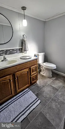 a spacious bathroom with a granite countertop toilet sink and mirror