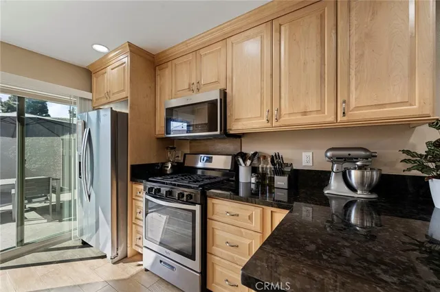 a kitchen with stainless steel appliances granite countertop a stove a refrigerator and a cabinets