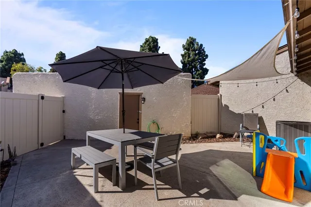 a patio with a table and chairs under an umbrella