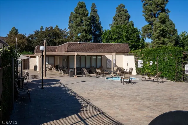 an outdoor view of a house with sitting area and garden