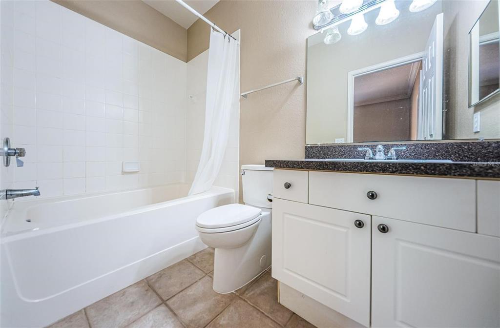 2254 Chianti Place, Unit 66 Palm Harbor, FL 34683 - Photo 12 of 20 a bathroom with a granite countertop toilet a sink and bathtub