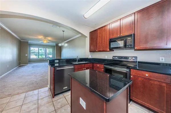 a kitchen with stainless steel appliances granite countertop a sink microwave and stove