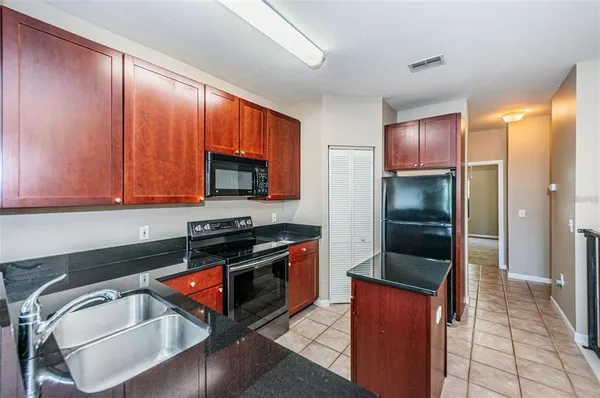 a kitchen with stainless steel appliances granite countertop a stove a refrigerator and a sink